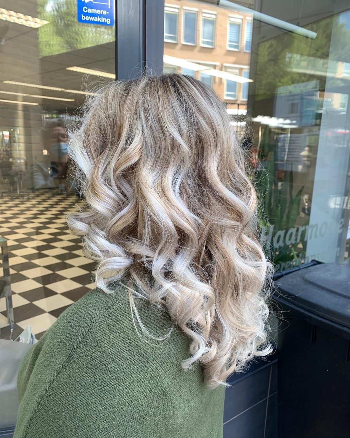 Blonde balayage met zachte krullen, gemaakt bij PC Haarmode