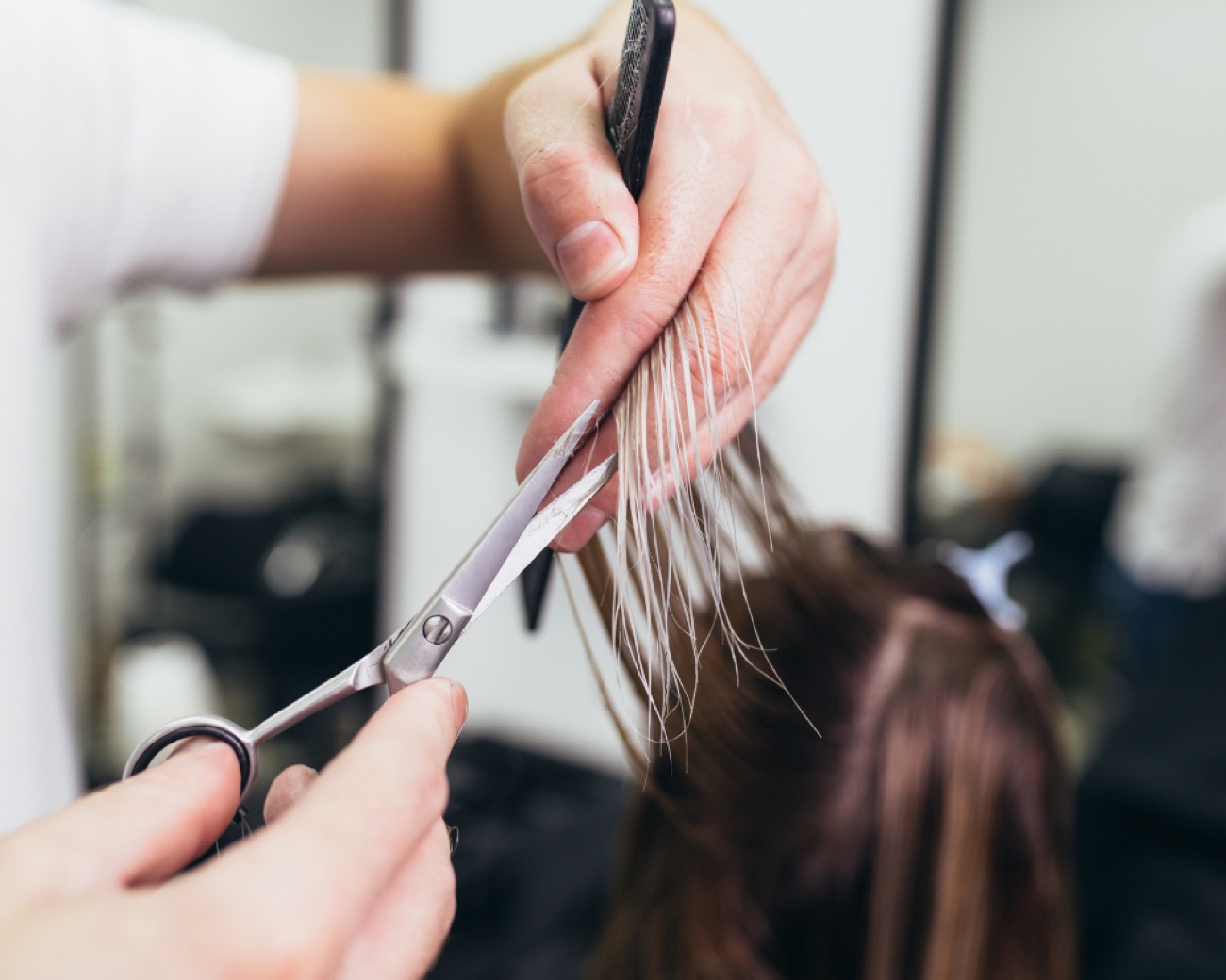 Kapper knipt het haar van een klant bij PC Haarmode
