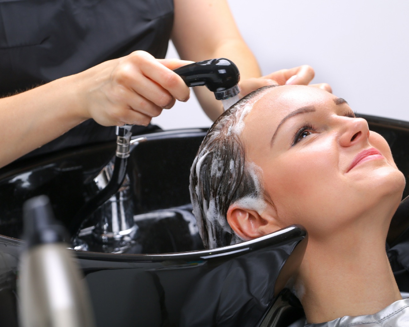 Haar wassen aan de wasbak in de salon